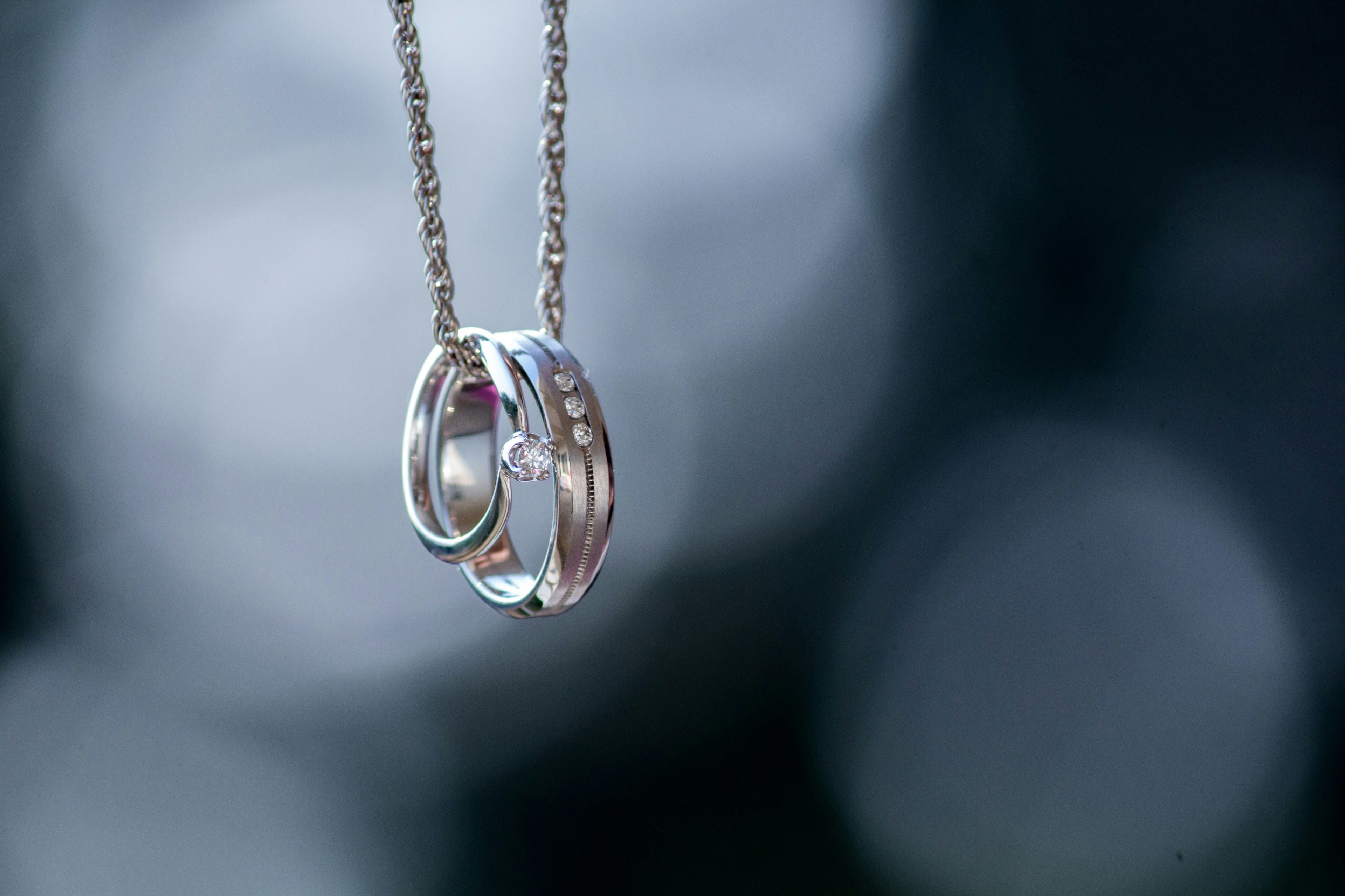 Silver necklace with interlocking rings against a blurred background